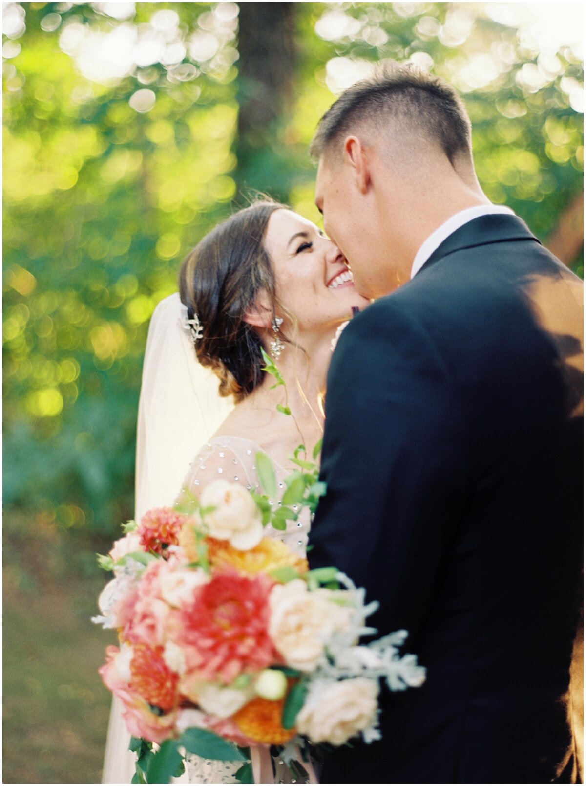 bride and groom kissing with peach and green bouquet knoxville wedding 