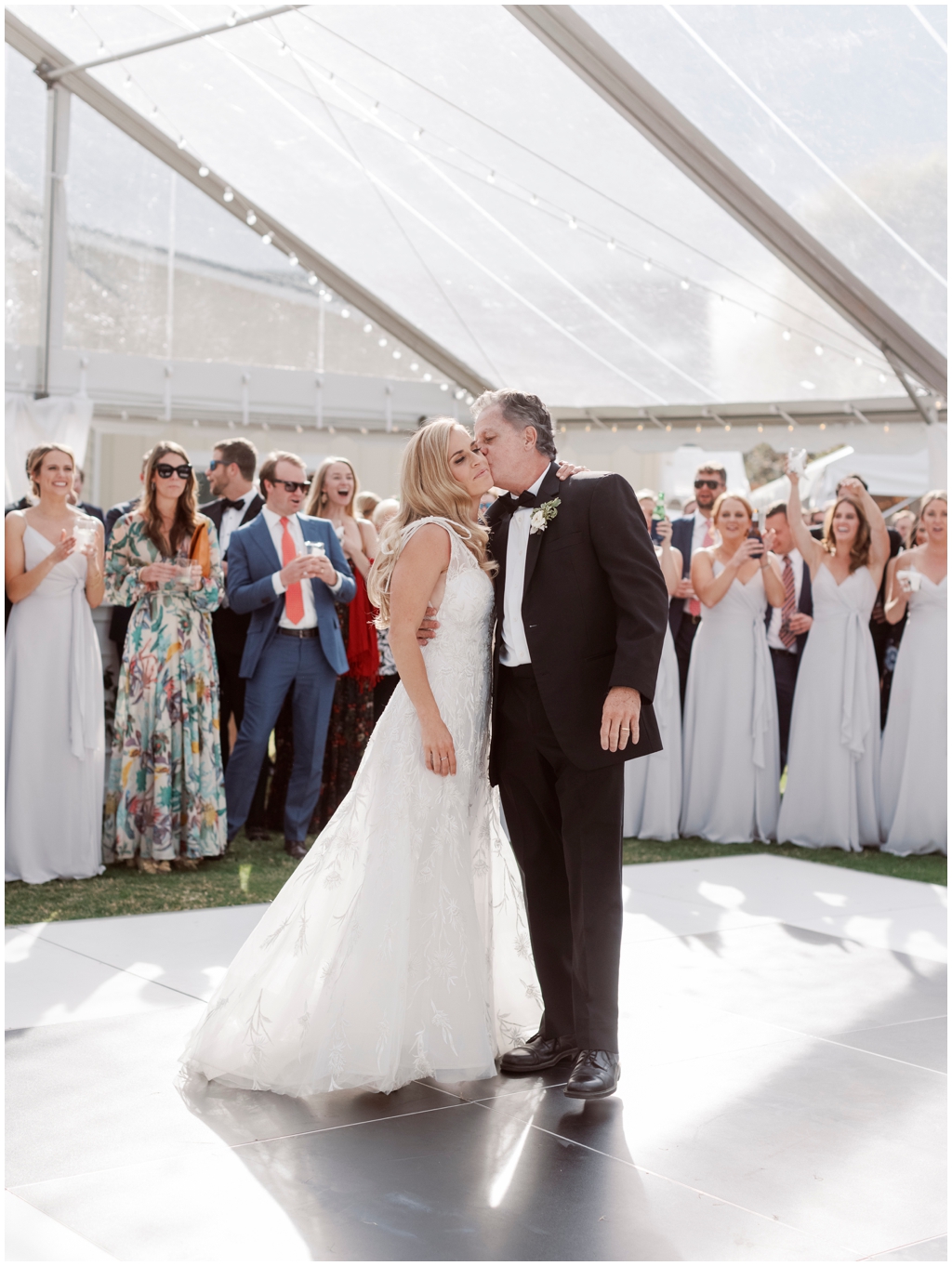 Father of the bride affectionately kisses bride on the cheek after their first dance. 