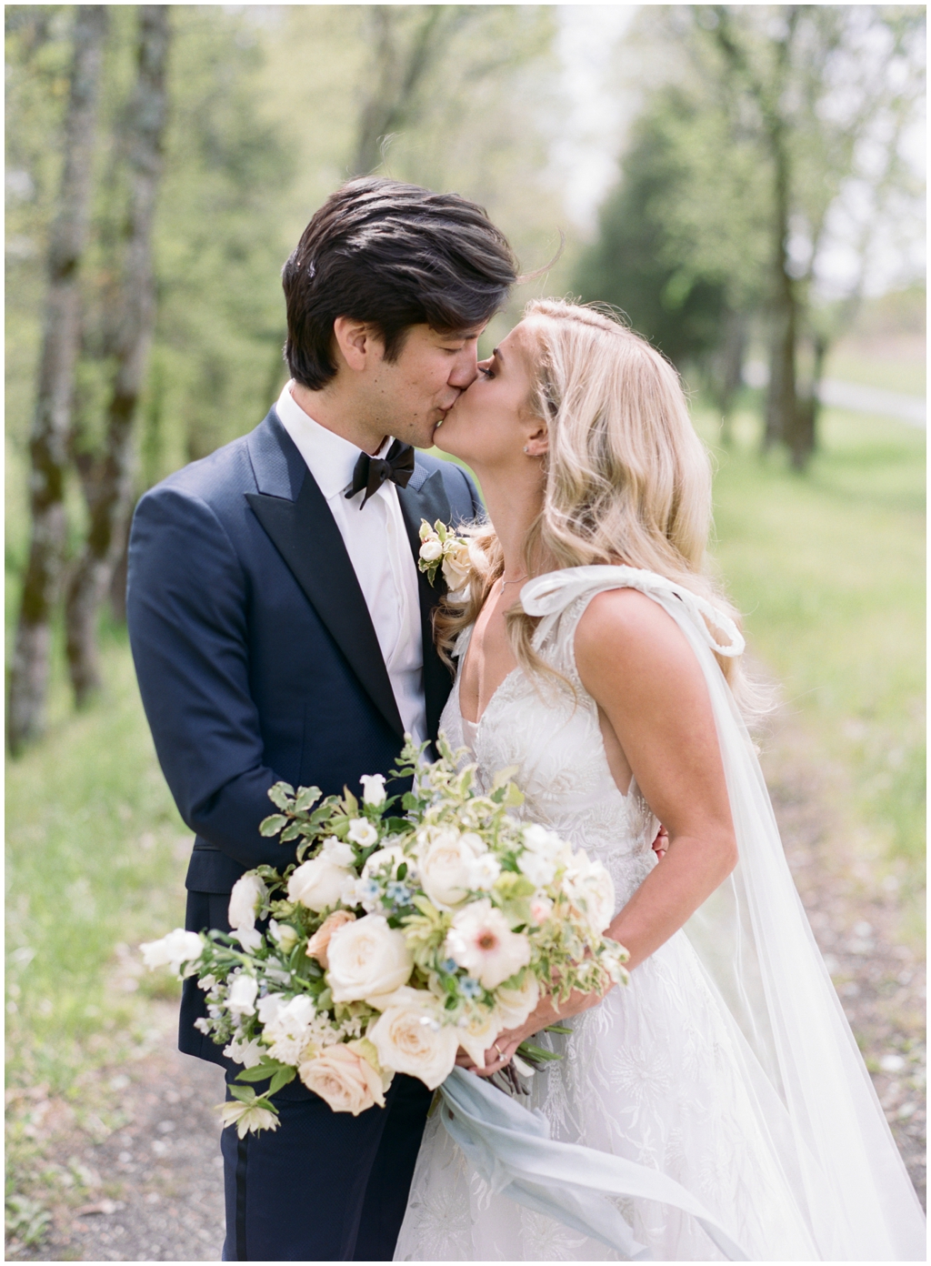 Bride and groom share a kiss at their portraits