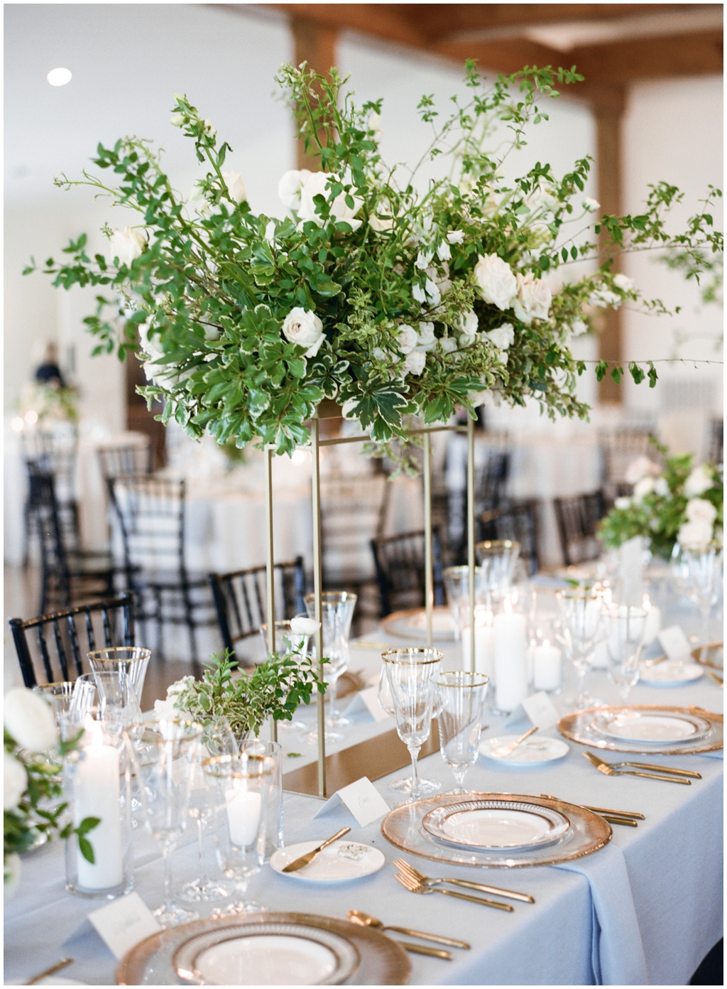 Tall centerpieces with lots of lucious greenery and roses and fine glassware at Marblegate Farm. 